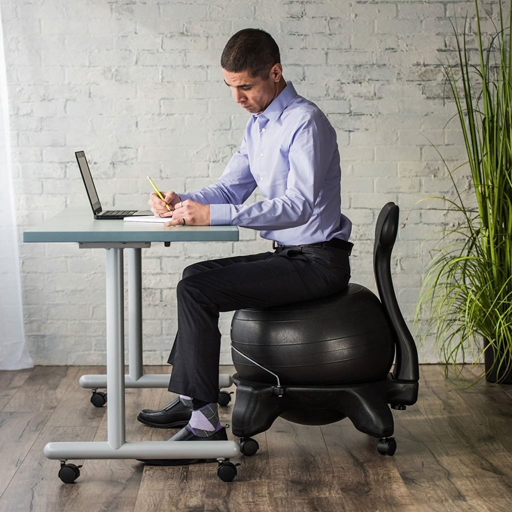 side view of a man sitting on the yoga ball