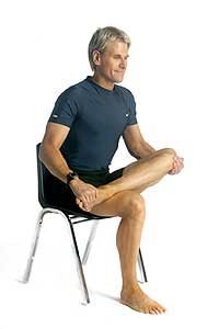man doing desk exercises for lower back pain chair seated hip stretch