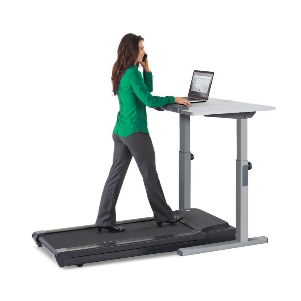 woman on the phone while walking on treadmill working on laptop desk